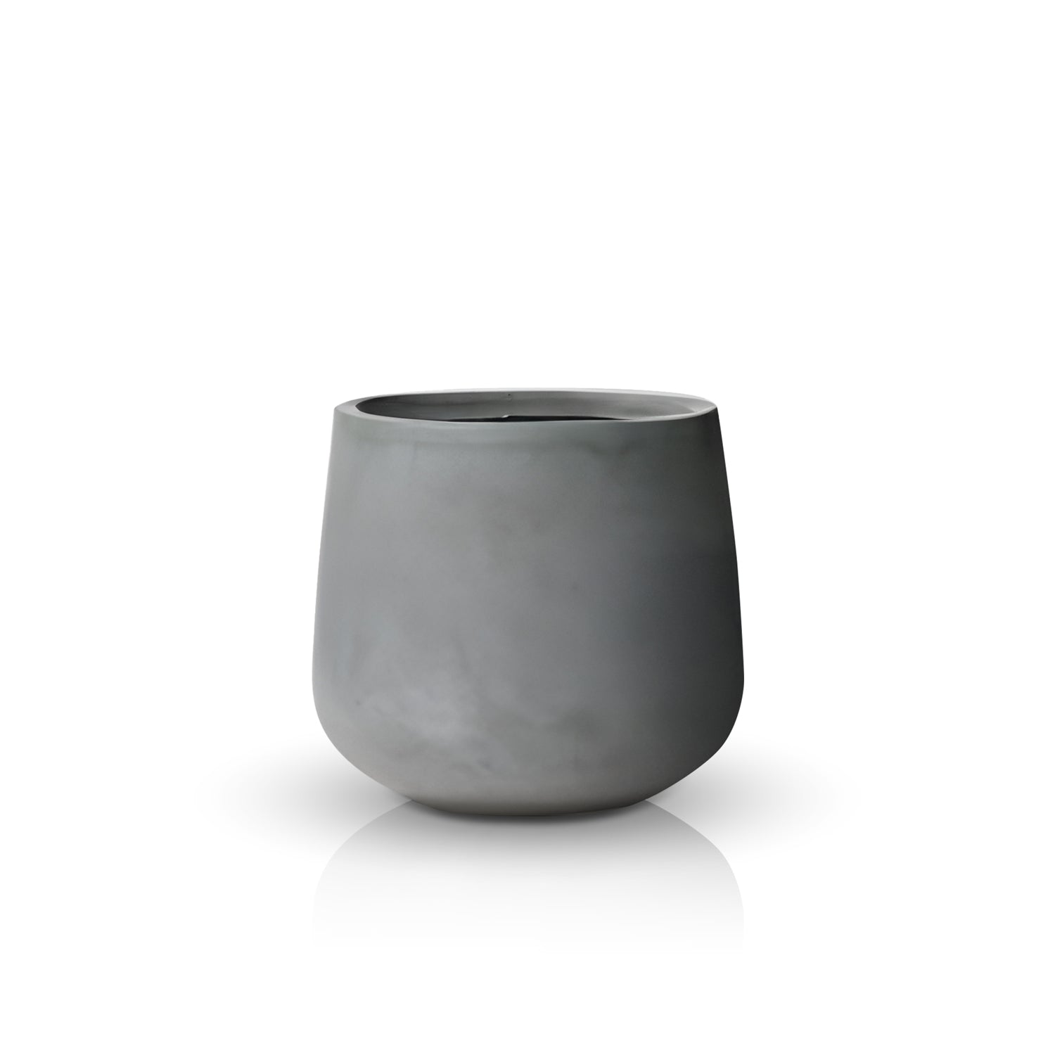 The Fortezza Planter - Medium by Landmark Decor is a handmade, smooth gray ceramic pot with a cylindrical shape, rounded base, and wide opening. It elegantly rests on a reflective white surface, effortlessly merging luxury with nature.