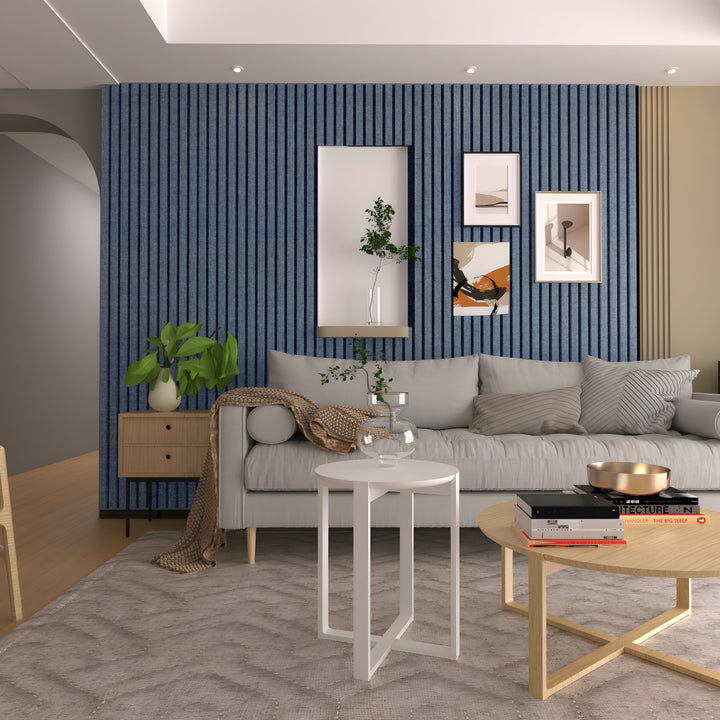 Modern living room featuring a gray sofa, Landmark Decor’s Navy Blue WPC Fluted Slat Wall Panel accent wall, stylish wall art, two round coffee tables, a beige rug, and decorative plants.