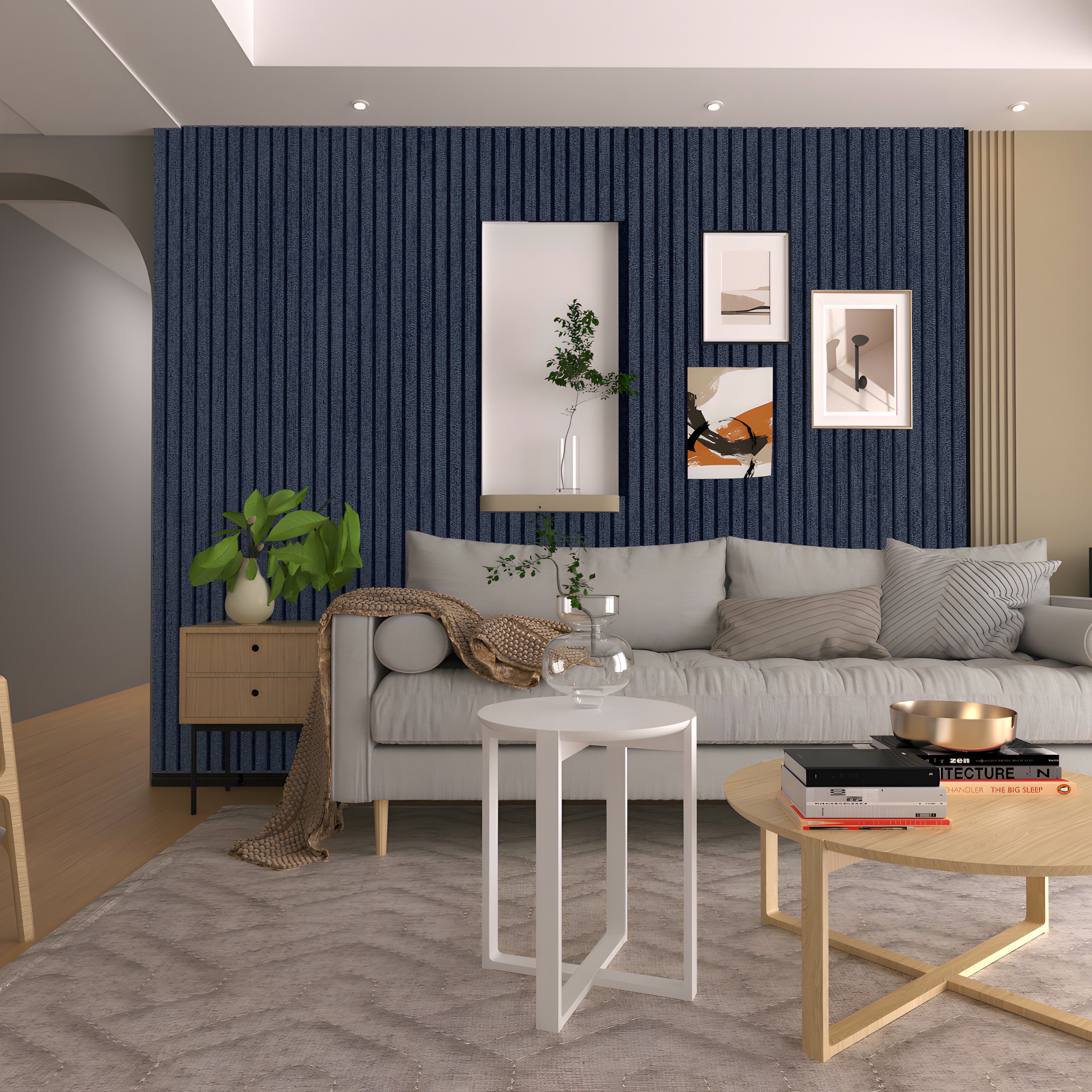 Modern living room with a gray sofa, light wood tables, decorative plants, and framed art on a Landmark Decor Navy Blue Frosted Effect Slat Wall Panel accent wall. A neutral rug covers the hardwood floor.